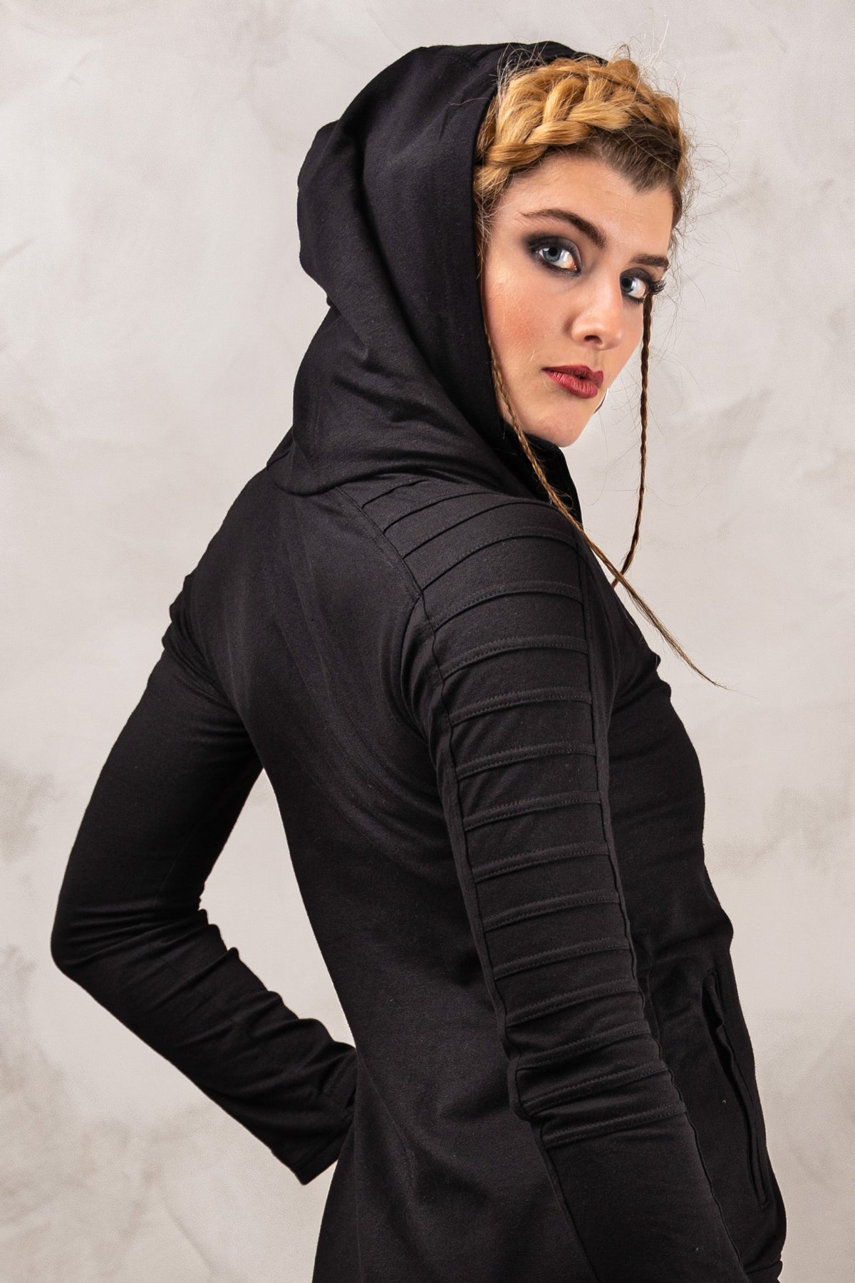 a woman in a black hoodie is posing for a picture