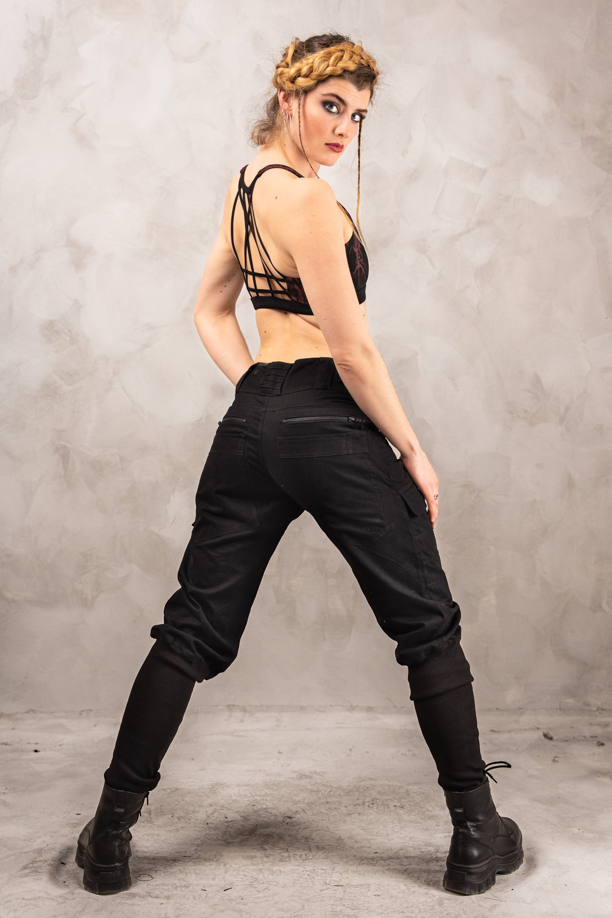 a woman in black pants and a bra top