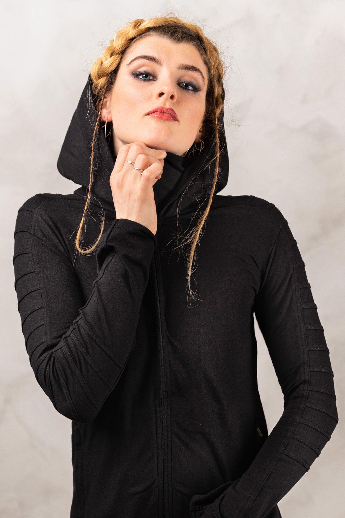 a woman in a black hoodie is posing for a picture